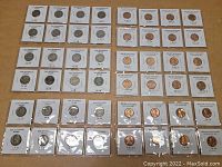 Top-down view of 61 old Lincoln cents and Jefferson nickels in coin holders, arranged in rows on a flat surface.