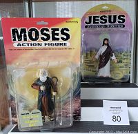 Photo of Moses and Jesus Bible action figures in original blister card packaging, shown with card backs displayed with text.