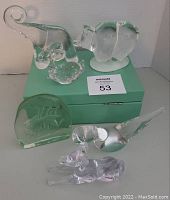 Overview of all six glass animal figurines showing their varying shapes, colors, and sizes on a green box.