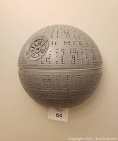 Photo of the Star Wars Death Star wall light turned off, showing the detailed grey plastic perforated surface mimicking the Death Star.