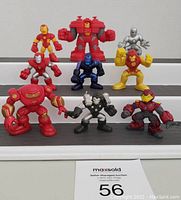 Front view of nine Marvel Super Hero Squad figures arranged on stairs showing variety of Iron Man and Hulkbuster characters.