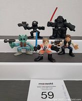 Front view of five Super Hero Squad Star Wars figures on a display step showing character details and accessories.