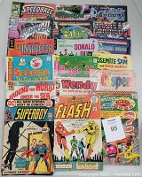 Lot of 30 vintage comic books laid out visibly showing varied titles and series predominantly from mid 20th century, worn condition.