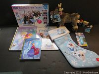 Full lot arranged showing all items including Sven plush, books, puzzle, stocking, figures.