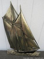 Full view of large gold sailing ship wall art sculpture with detailed sails and rigging, mounted on white wall.