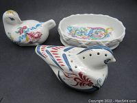 Set of three Elizabeth Arden ceramic collectible pieces including bird-shaped pomander, bird-shaped potpourri holder, and soap/trinket dish with colorful decorative details.