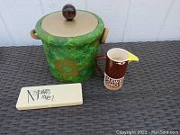 Overview photo showing green Kraftware floral ice bucket, brown Smirnoff Hawk Shot pitcher, and plastic case for drink markers.