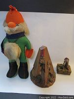 Three items: large plush Scandinavian elf/troll doll, Metrognome elf metronome, Pixies trinket box elf figurine with frog on base.