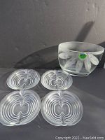 Photo showing four clear glass plates with apple-shaped concentric rings, flat and stacked together.