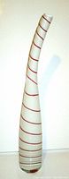 Tall, slender Murano glass vase with white base and red spiral stripes, shown against a white background.