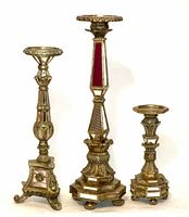 Three gilt gold mirrored Baroque candle holders of varying heights arranged side by side, showing overall appearance and design details.