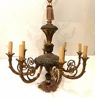 Front and side view of the Italian bronze and gold 8-light campaign chandelier showing detailed scrollwork and tassel decoration.
