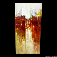 Front view image of a tall giclee canvas print showing an abstract cityscape in warm tones of orange, red, yellow, and beige on a black background.