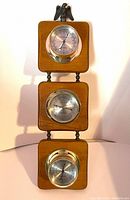 Full front view showing three brass instruments mounted on wooden plaques connected vertically with bronze eagle on top, on white background.