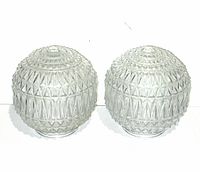 Pair of vintage cut glass light globe covers placed side by side, showing diamond and triangle geometric patterns.