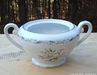 Front angle showing sugar dish shape, two handles, floral design, and silver trim.