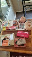 Lot overview showing 8mm film reel, office kit, rock salt candle holders, Coca-Cola wallet, assorted cards, and vintage hearing aid in packaging