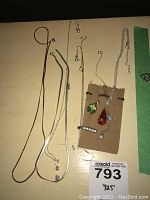 Overview of six silver chains and three pendants on surface