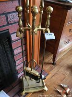 Front view of the fireplace tool set on stand showing tools and finials