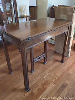Full view of the solid wood table showing rectangular top, carved legs and partial leaf expansion.