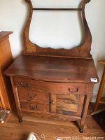 Full view of the wash stand showing lyre back, tabletop, drawers, and wheels