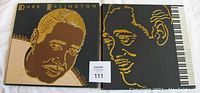 Two black box sets with gold artistic portraits of Duke Ellington on the covers, showing front view of both box sets together