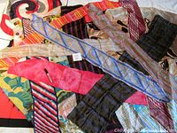 Photo showing assorted neckerchief scarves laid out with various colors and patterns including stripes, plaids, and abstract prints