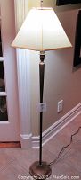 Full view of the floor lamp showing the base, pole, and lampshade.