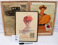 Front view of all three vintage advertising prints, two framed and one on board, arranged with a Sharpie for scale.