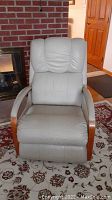 Front view of single putty-colored leather recliner with oak arm trim