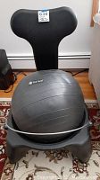 Front view showing the Gaiam exercise ball seated in the black plastic chair base with the adjustable back rest visible.