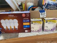 LED lightbulb packs with Relax LED 8-pack and 2 boxes of Rough Service garage door opener bulb boxes on display