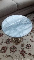 Top view showing the round marble tabletop with gray veining and smooth finish.
