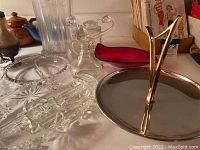 Various serving pieces made of glass, metal, and wood including trays, cruets, and salt and pepper shakers.