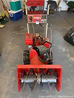 Front view of red Toro 421 snowblower showing auger housing and handles