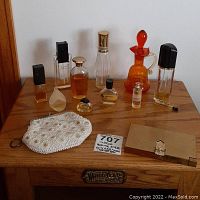 Full view of 10 vintage perfume bottles, white beaded coin purse, gold tone makeup compact, small cloisonné compact