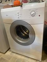 Front view of white Whirlpool dryer alongside washer