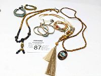 Top view of the mala necklaces, bracelets laid out on white surface with lot number card.