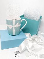 Front view of Tiffany & Co Blue Ribbon China Mug with original Tiffany blue box, white satin ribbon and protective bubble wrap inside the mug.