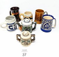 Overview photo of seven vintage ceramic mugs and steins of varying shapes, sizes, and colors.