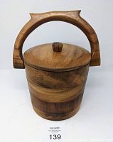 Closed wooden ice bucket with carved wooden handle and lid showing natural wood grain and finish.