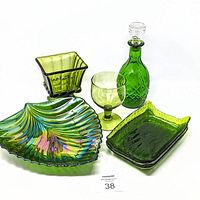 Group photo showing all green glass items in the lot on a white background with lot number card