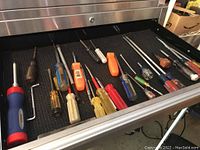 Drawer of approximately 20 assorted manual screwdrivers with plastic and wood handles