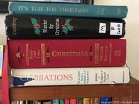 Photo showing four Christmas-themed books stacked horizontally: It's Time for Christmas, Murder for Christmas, Christmas Prose and Verse Deluxe Edition, and Celebrations companion book.