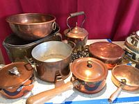 Overview of entire assortment showing bowls, pots, kettle and hangers