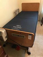 Assembled Invacare bed with NPT3 Envy G Series mattress, footboard visible