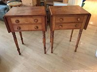 Pair of matching wooden drop-leaf side tables with two front drawers and turned legs