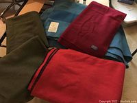 Overview of five folded wool blankets showing colors and labels