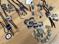 Overview of mixed sterling silver jewelry laid out on wood floor