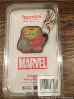 Clear photo of sealed package showing Marvel Foundmi Bluetooth tracking keychain shaped like Iron Man helmet with Avengers logo.